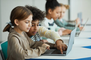 kinderen op laptop in klaslokaal digitale geletterdheid