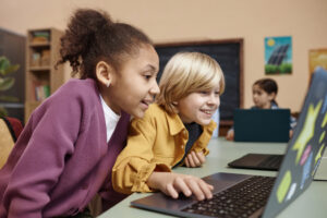 Kinderen werken samen aan digitale opdrachten op een laptop – plezier in digitale geletterdheid op de basisschool
