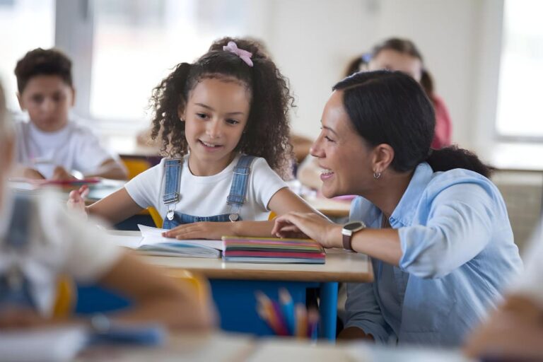 Leerkracht stelt coachende vragen aan leerling tijdens lesmoment, met focus op eigenaarschap en leren.