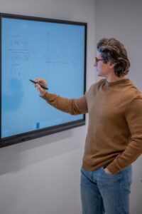 Docent geeft gestructureerde instructie bij digitaal bord volgens het EDI-model – voortgezet onderwijs of mbo.