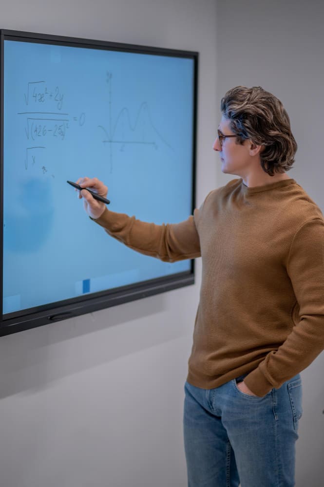Docent geeft gestructureerde instructie bij digitaal bord volgens het EDI-model – voortgezet onderwijs of mbo.