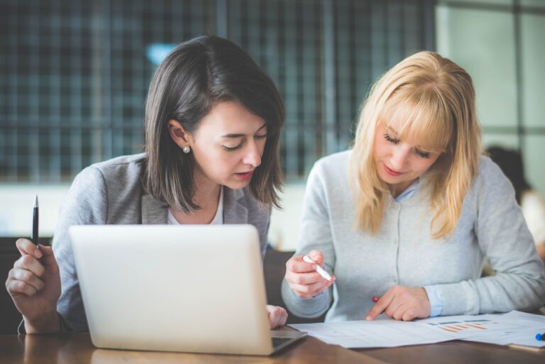 Twee schoolleiders bespreken kwaliteitsbeleid en analyseren documenten op laptop en papier