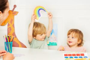 Kinderen oefenen met kleuren, vormen en woordenschat met pedagogisch medewerker in VVE groep.