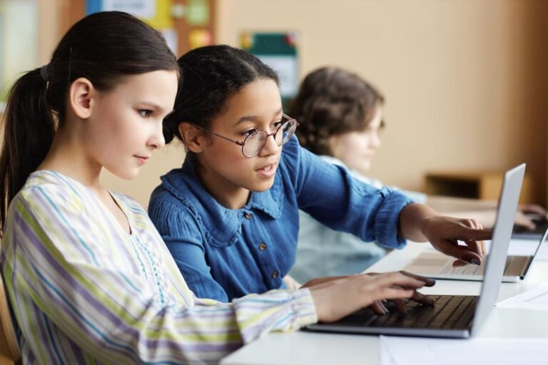 Leerlingen werken aan opdracht op laptops, oefenen met digitale geletterdheid van basisvaardigheden po.