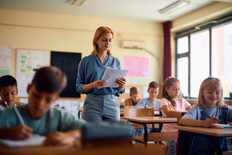 Leerkacht geeft les aan betrokken groep leerlingen die actief leren.