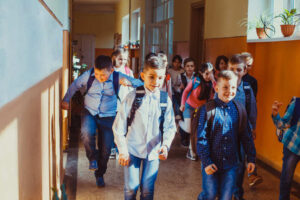 Groep kinderen loopt door de gang van de school als groep.