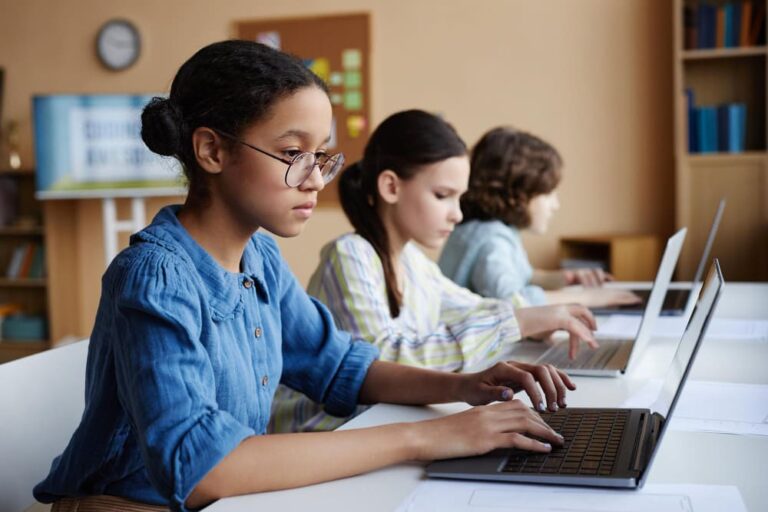 Leerlingen werken in de klas met digitale middelen aan digitale geletterdheid, onderdeel van de opleiding Expert Digitale Geletterdheid.