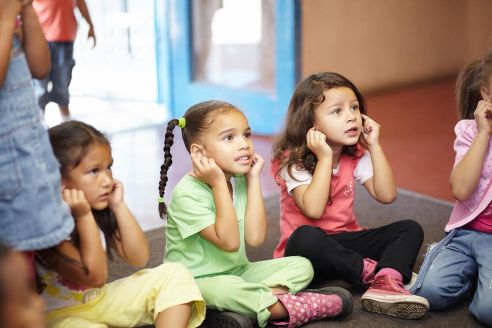 Groep kleuters doet actief mee met kringactiviteit van startende kleuterleerkracht.