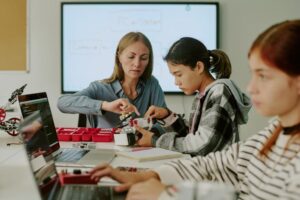 Docent ondersteunt hoogbegaafde leerling bij uitdagende taak in het klaslokaal.