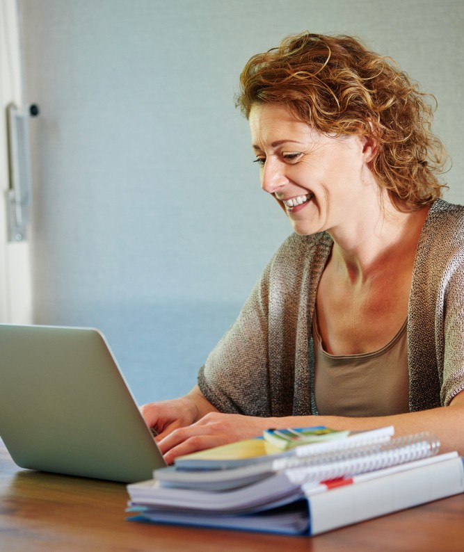 Intern begeleider aan het werk achter laptop met leerlingdossiers, straalt werkplezier en rust uit.