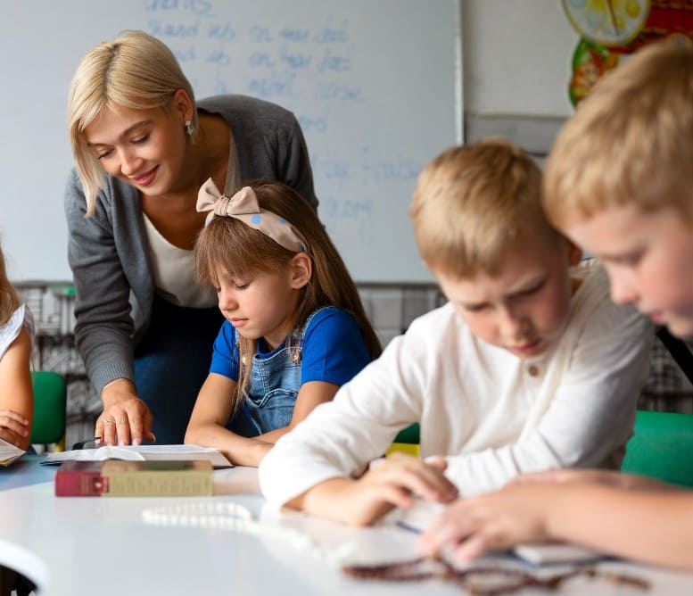 Leerkracht ondersteunt leerlingen tijdens een stille leessituatie in de klas, boeken open op tafel.