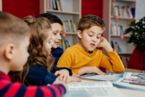 leerlingen lezen samen teksten in schoolbibliotheek en bespreken de inhoud.